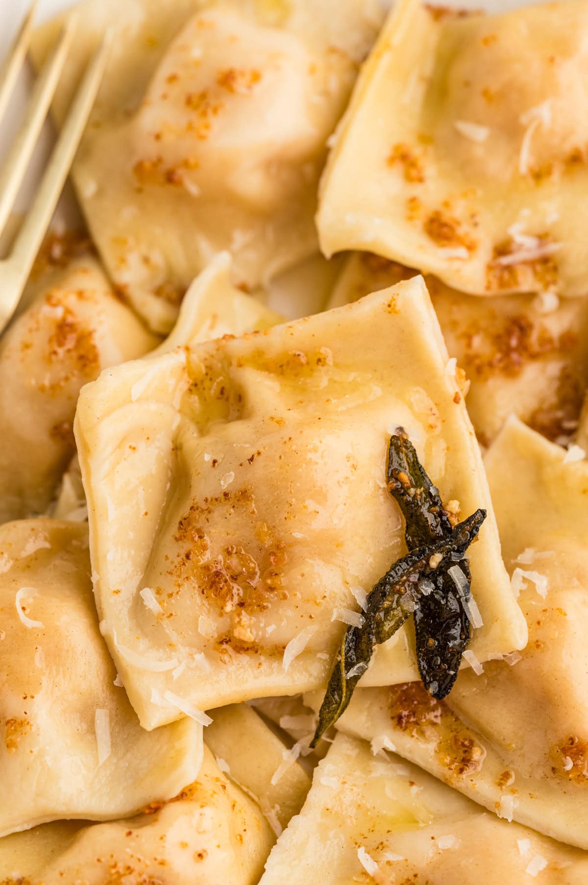 This Butternut Squash Ravioli Recipe is like a little slice of heaven made with fresh homemade dough and a mascarpone and butternut squash filling. Close-up of ravioli.