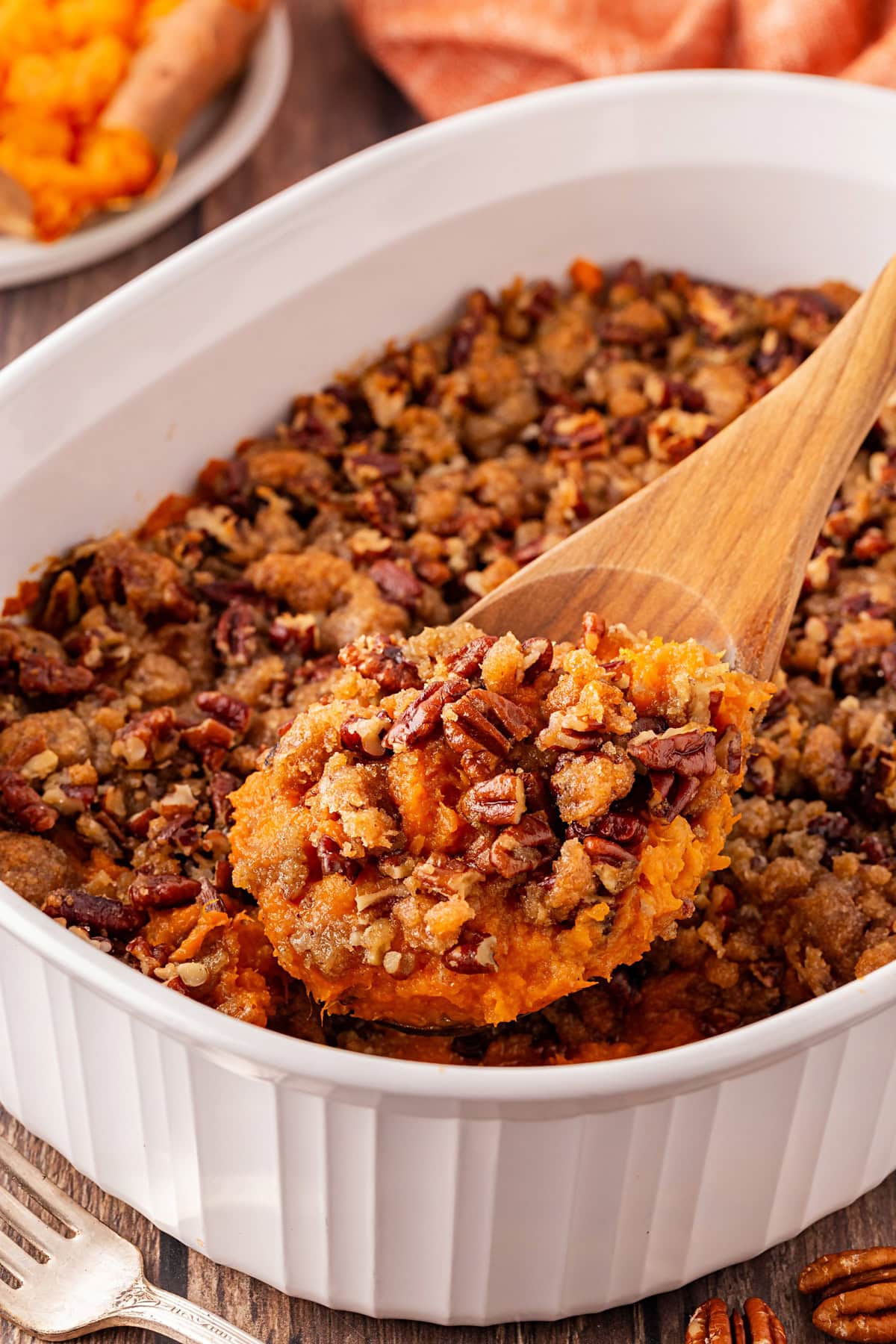 This Ruth's Chris Copycat Sweet Potato Casserole is winner of a make ahead casserole and side dish for your Thanksgiving or Christmas feast. The crunchy topping will have you going back fore more. Taking a spoonful of Ruth's Chris Sweet Potato Casserole.