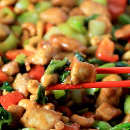 Red chop sticks used to pick up from a pan of stir fry.