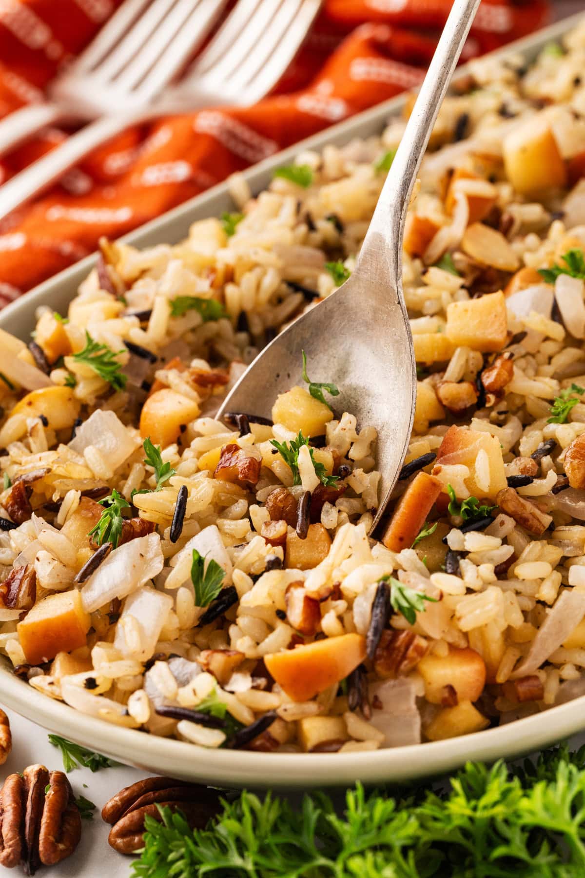 These 32 Amazing Thanksgiving/Holiday Sides will be your go to roundup for all your side dishes for family and friend celebrations for the season. Putting a spoon into the wild rice dish.
