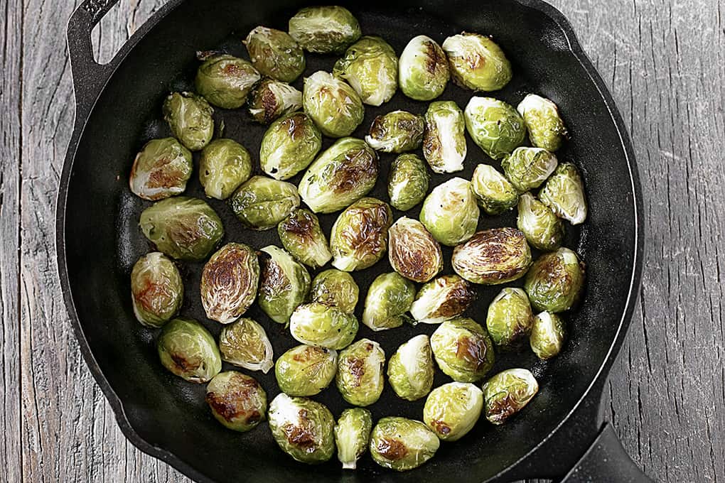This Roasted Brussels Sprout Recipe with Parmesan is an easy side dish that will be perfect with so many meals!! #Brusselssprouts #sidedish #Parmesan Roasted Brussels Sprouts in Skillet