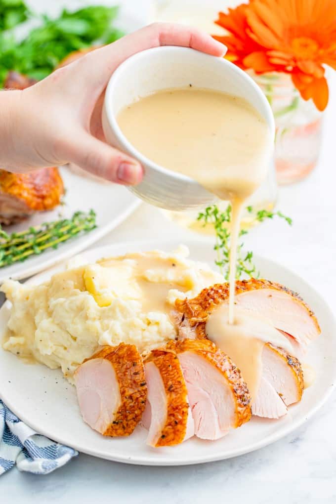 The Quintessential Guide for Smoking a Turkey will help you through brining, smoking and the best gravy ever! You won't find a better turkey than this. Pouring gravy on sliced turkey breast