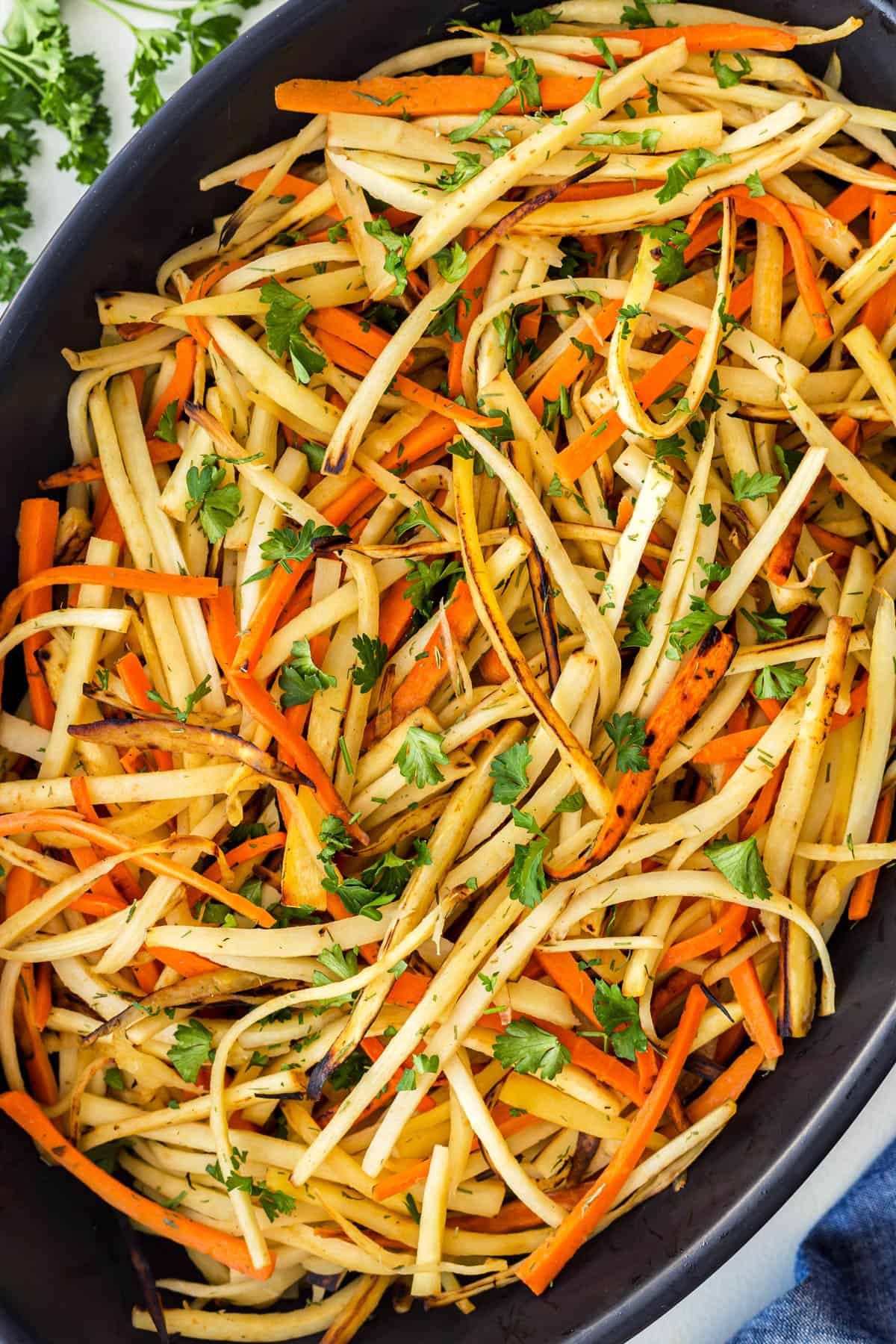 his amazing Pan-Fried Carrot and Parsnip Recipe is perfect for the holidays or for any time of the year when you want a delicious and lighter side dish. The crisp ends of the root vegetables will have you wanting more and more. Close-up of matchstick pan-fried carrots and parsnips in a casserole.