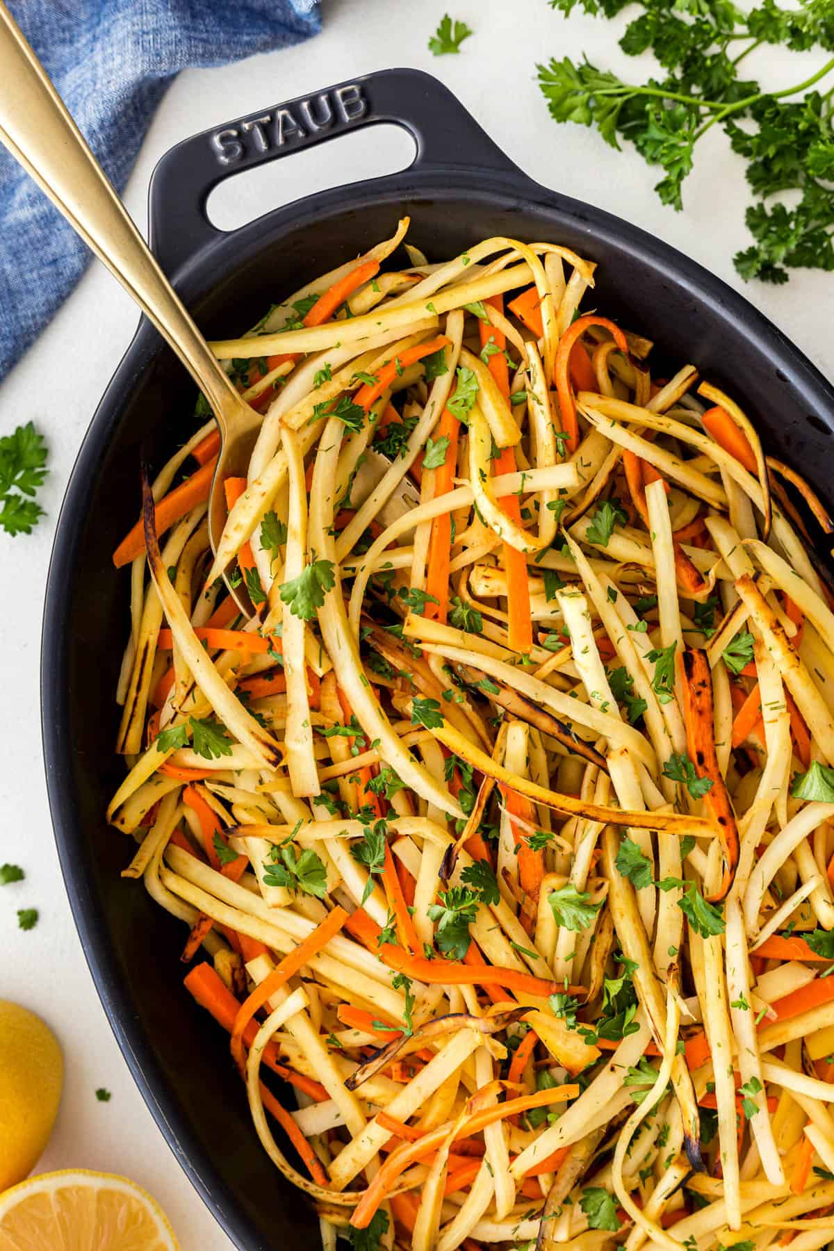 This amazing Pan-Fried Carrot and Parsnip Recipe is perfect for the holidays or for any time of the year when you want a delicious and lighter side dish. The crisp ends of the root vegetables will have you wanting more and more. Overhead picture of Pan-Fried Carrot and Parsnip Recipe in a casserole with a spoon.