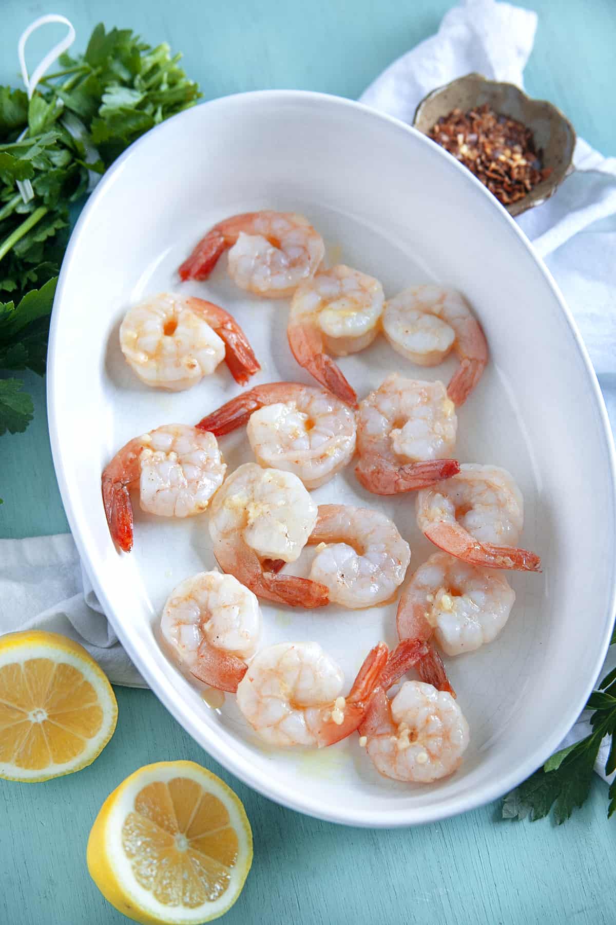 This Shrimp Scampi is a delicious dish to share for Valentine's Day or an anniversary. The succulent garlic butter shrimp are always a hit. Garlic shrimp in a white casserole, shot overhead.