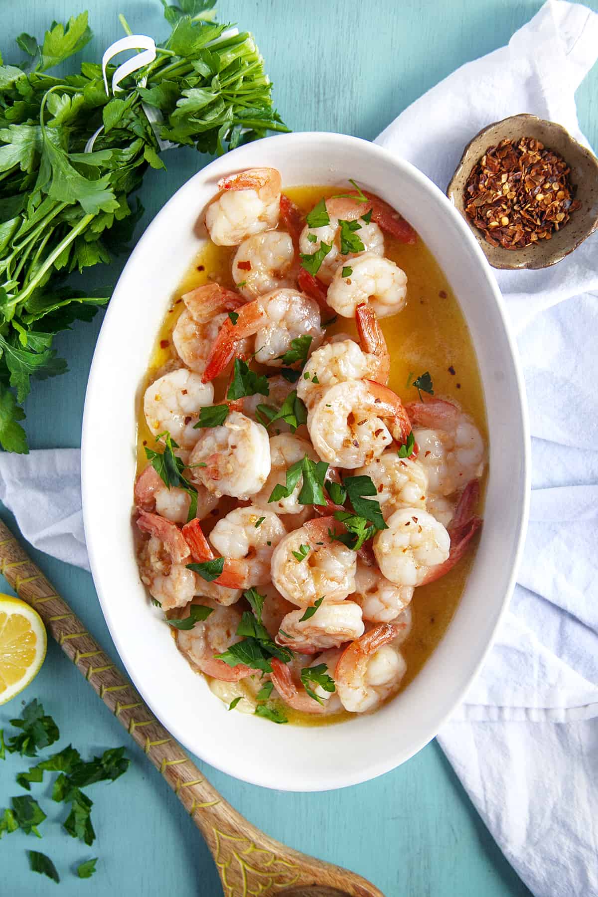 This Shrimp Scampi is a delicious dish to share for Valentine's Day or an anniversary. The succulent garlic butter shrimp are always a hit. Overhead shot of shrimp scampi in an oval white casserole dish.