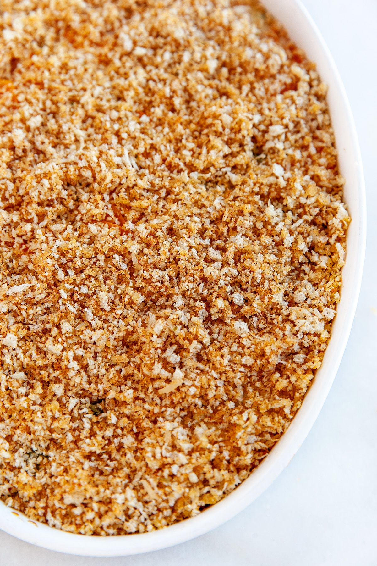 This Sweet Potato Au Gratin will be a hit with family and friends for the holidays. With a creamy herb and cheese flavored sauce and a crunchy savory topping - what is not to love!! Close up showing the bread crumb topping.