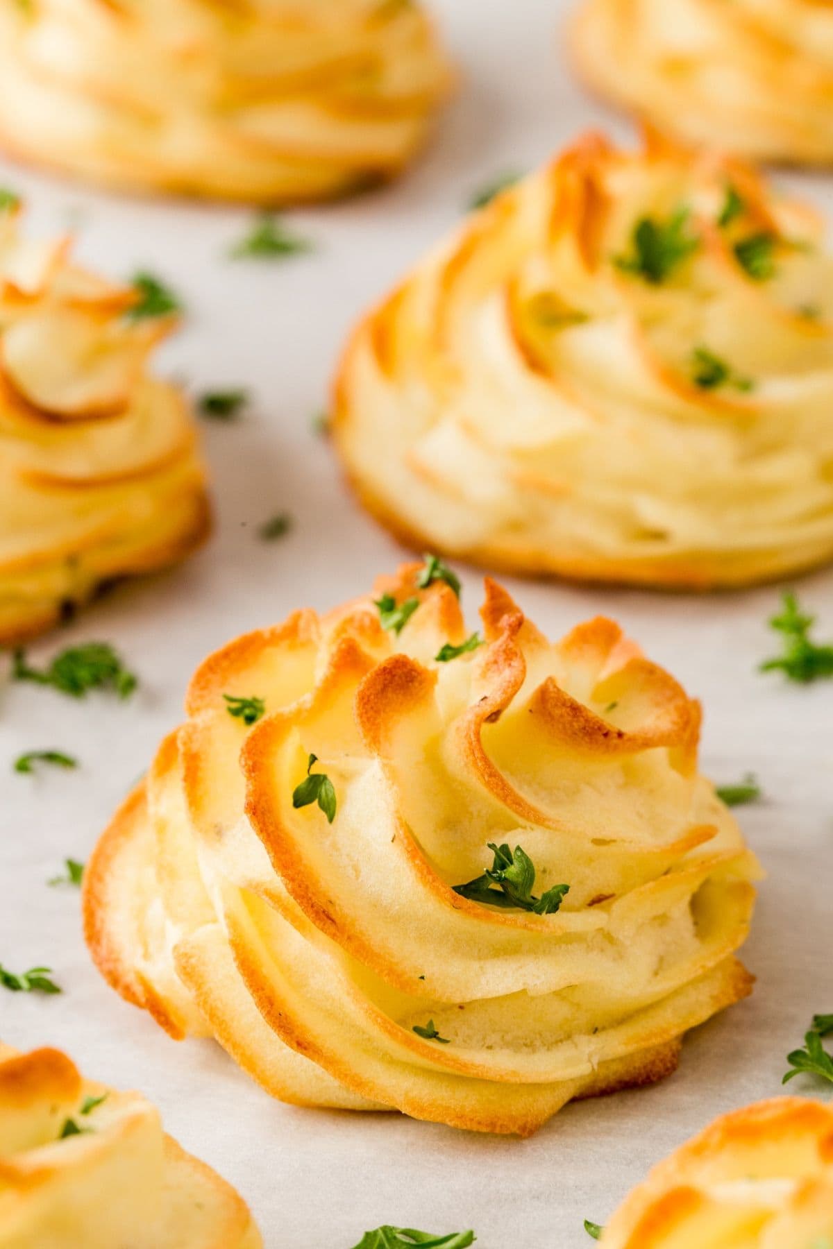 These 32 Amazing Thanksgiving/Holiday Sides will be your go to roundup for all your side dishes for family and friend celebrations for the season. Baked dutchess potatoes on a parchment lined baking sheet.