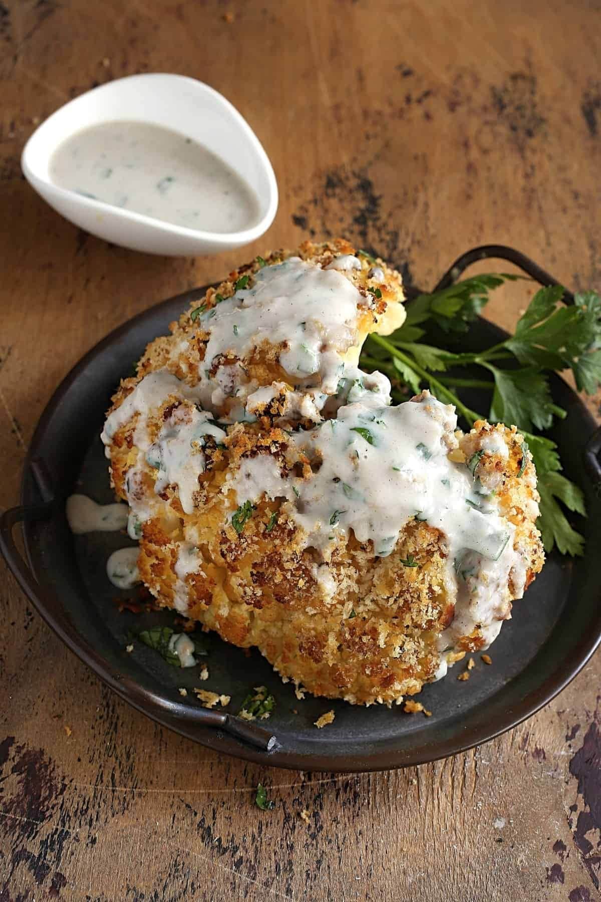 These 32 Amazing Thanksgiving/Holiday Sides will be your go to roundup for all your side dishes for family and friend celebrations for the season. Head of roasted cauliflower on a plate with some fresh parsley.