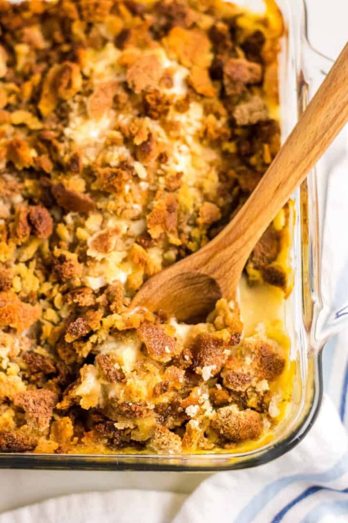 This 25 New Holiday Casserole Roundup will help you finish off all your holiday menus with a delicious side dish or main. So many to choose from, you will want to try more than one. Wooden spoonful of chicken stuffing casserole being removed from the baking dish.