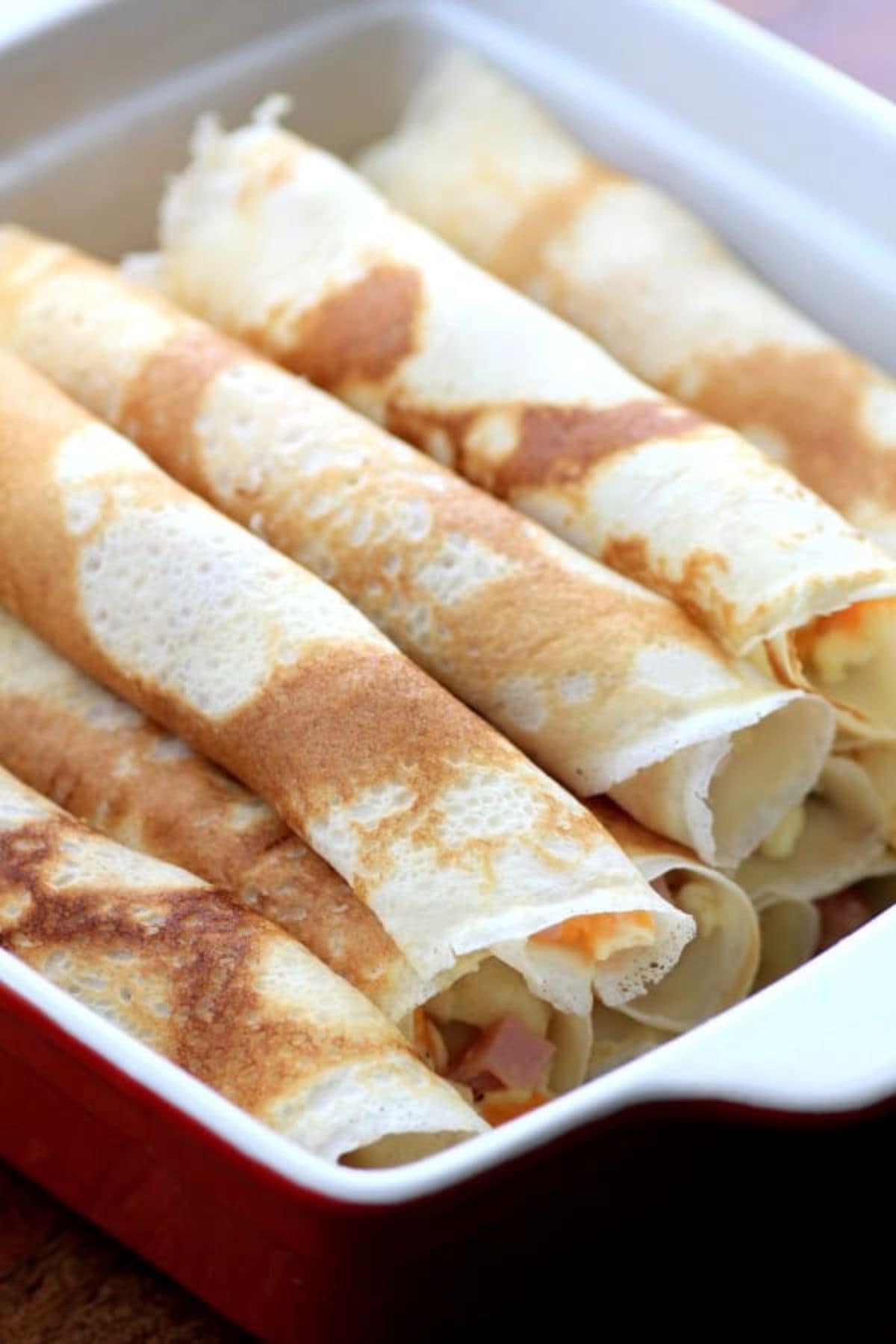 These 35 Scrumptious Make Ahead Brunch Casseroles will make your life over the holidays so much easier. Plus, everyone will be delighted with any one of these casseroles for the holidays. Crepes in baking dish.